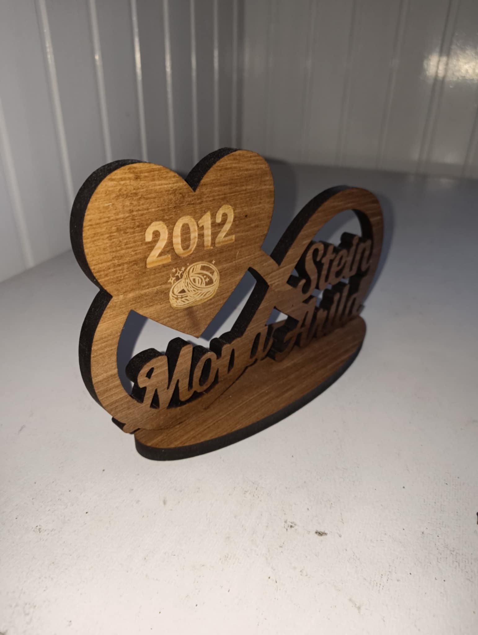 Utskåret evighetstegn med navn og årstall