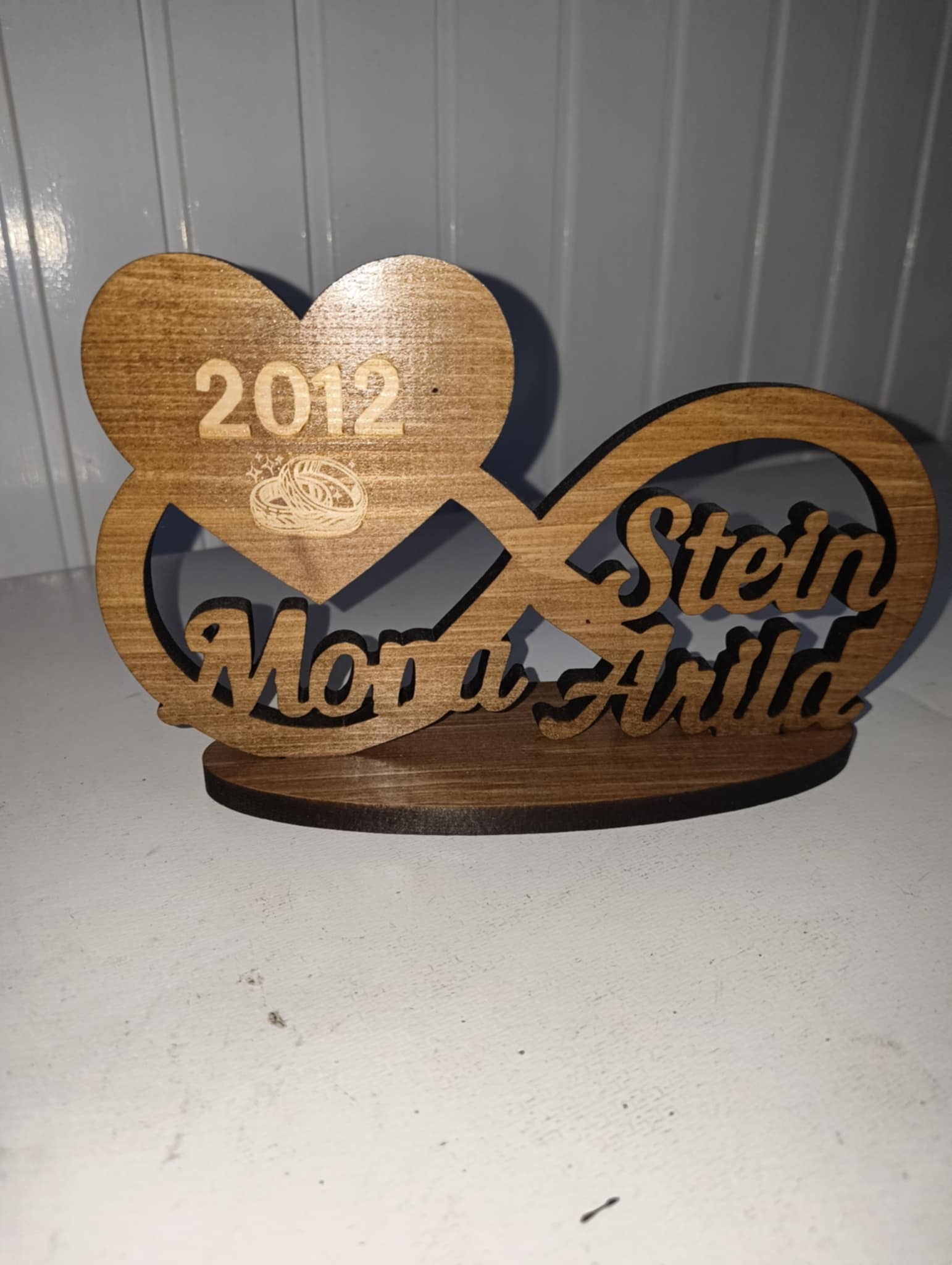 Utskåret evighetstegn med navn og årstall